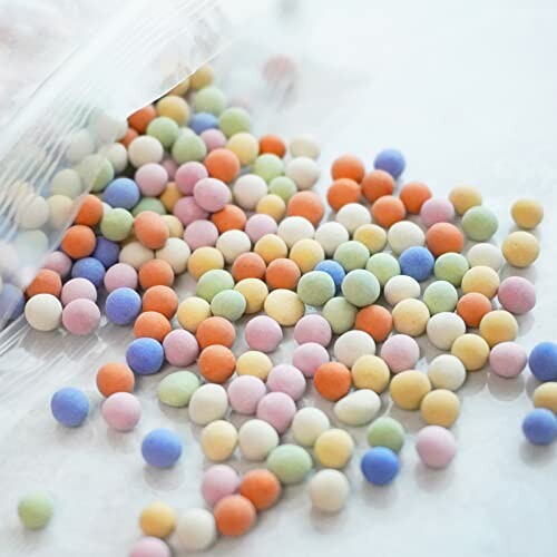 Colorful round candy sprinkles spilling from a bag